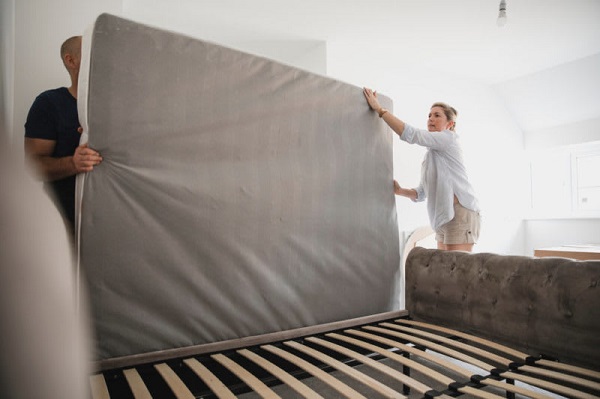 A couple moving a mattress
